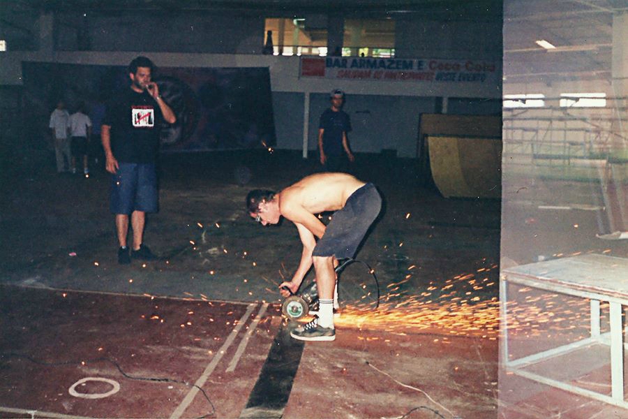 Homem prepara o piso de um galpão para o torneio de skate